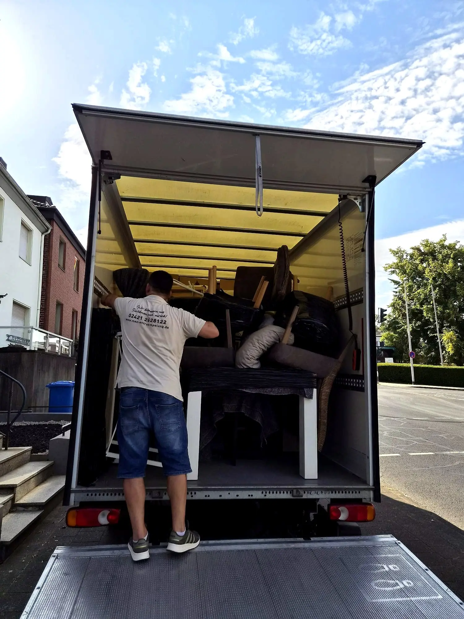 MEX-Team belädt den Umzugswagen an der Straße in Düren